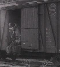 People riding in a boxcar.